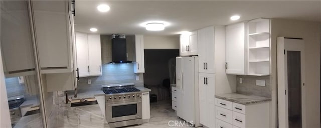 kitchen featuring white cabinetry, wall chimney range hood, white refrigerator with ice dispenser, and high end stainless steel range