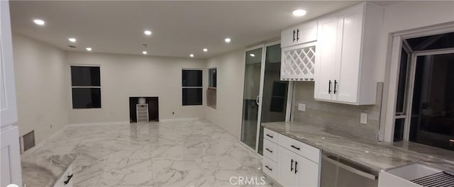 kitchen with dishwasher, light stone countertops, decorative backsplash, and white cabinets