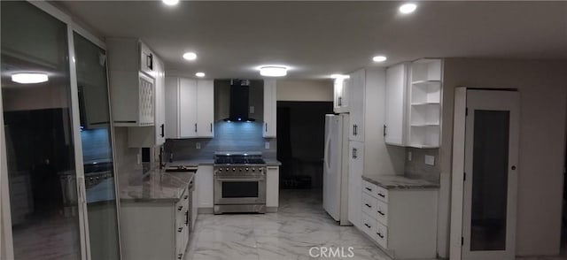 kitchen with white cabinets, backsplash, high end stainless steel range oven, white fridge, and wall chimney range hood