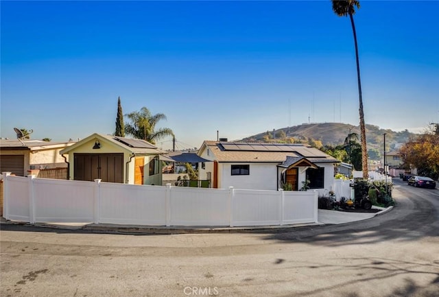 view of front of home with a mountain view and solar panels