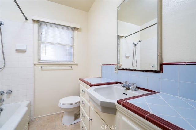 full bathroom with toilet, tiled shower / bath, tasteful backsplash, and vanity