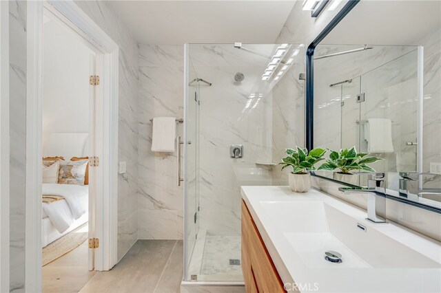 bathroom featuring a shower with door and vanity