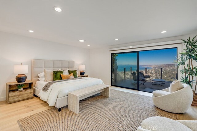 bedroom with access to exterior and light wood-type flooring