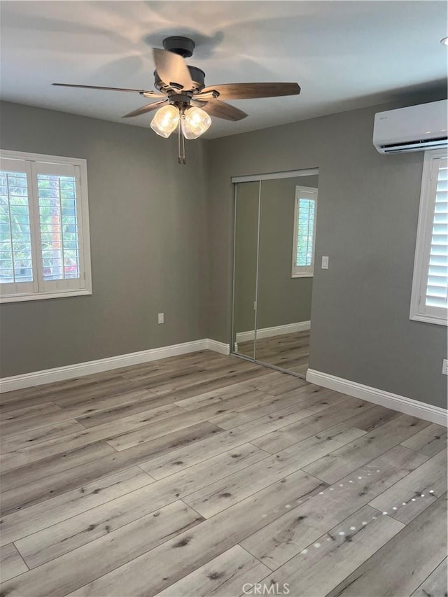 spare room featuring light hardwood / wood-style flooring and a wall unit AC