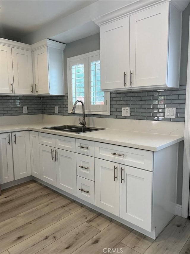 kitchen featuring sink, white cabinets, and light wood-type flooring