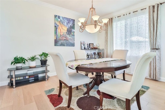 dining area with light hardwood / wood-style flooring, a chandelier, and ornamental molding