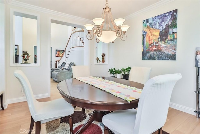 dining area with a chandelier, crown molding, and light hardwood / wood-style flooring