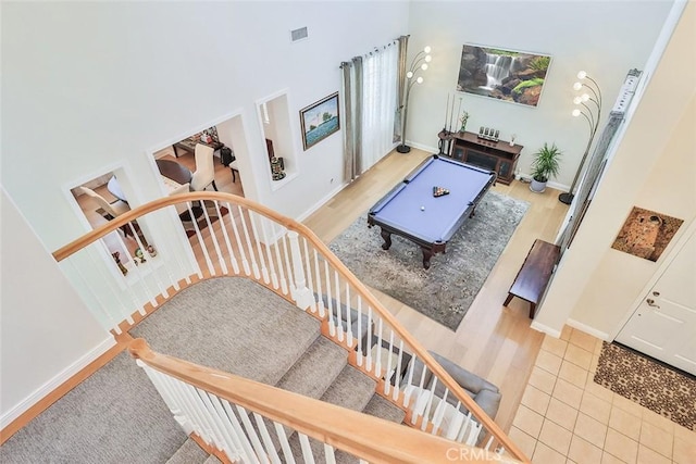 interior space with a high ceiling, tile patterned floors, and pool table