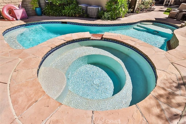 view of pool featuring an in ground hot tub