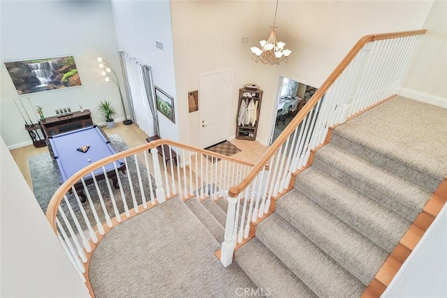 staircase featuring a towering ceiling and a chandelier