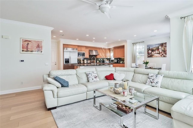 living room with ceiling fan, light hardwood / wood-style floors, sink, and crown molding