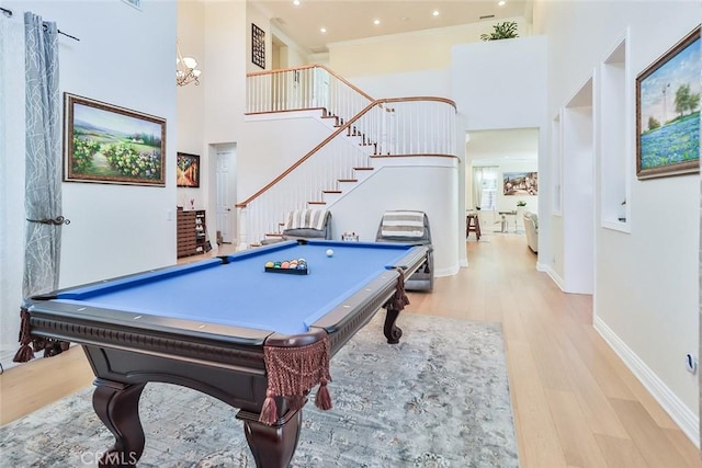 recreation room with crown molding, billiards, light wood-type flooring, and a high ceiling