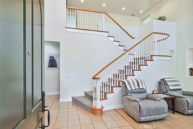 stairs featuring crown molding and tile patterned floors