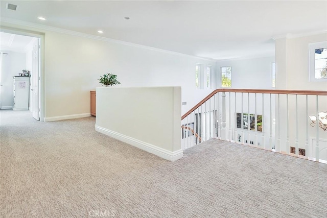 hallway with ornamental molding and light carpet