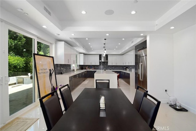 dining area featuring sink and a raised ceiling