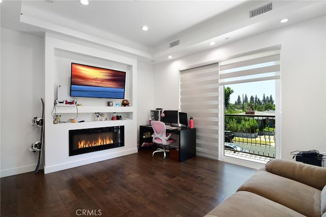 living room featuring dark wood-type flooring and a raised ceiling