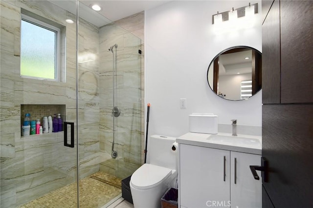 bathroom featuring toilet, a shower with door, and vanity