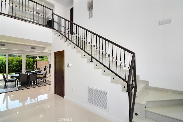 staircase featuring a high ceiling