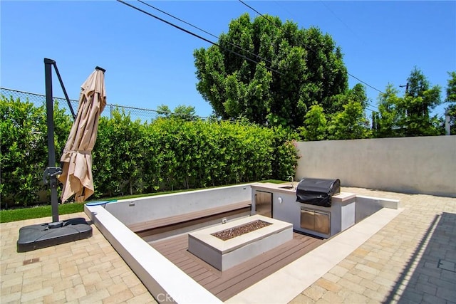 view of patio / terrace featuring an outdoor fire pit, an outdoor kitchen, and a grill