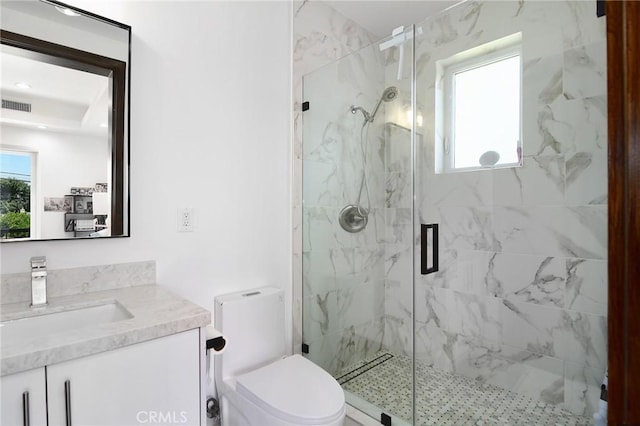 bathroom with toilet, vanity, and a shower with shower door