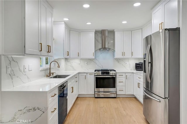 kitchen with tasteful backsplash, sink, white cabinetry, appliances with stainless steel finishes, and wall chimney exhaust hood