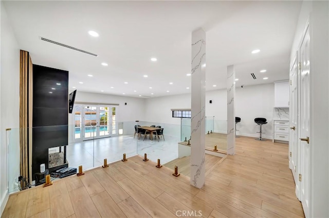 exercise room featuring light hardwood / wood-style floors and french doors