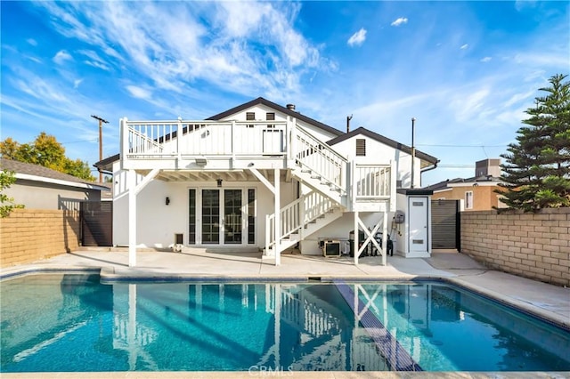 rear view of property featuring a patio area and a swimming pool side deck