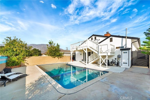 view of swimming pool featuring a patio area and a deck with mountain view