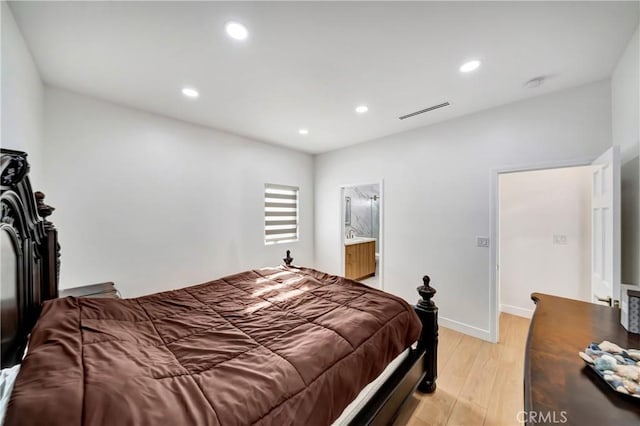 bedroom with light hardwood / wood-style floors and connected bathroom