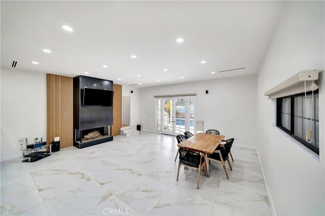 dining space with french doors and a large fireplace