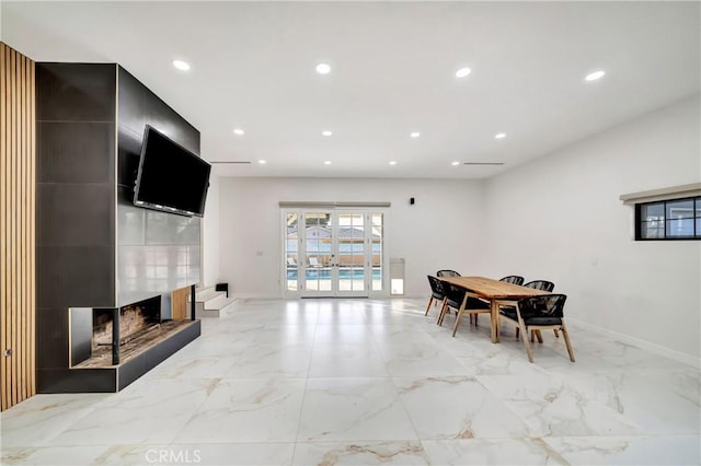 dining area with a multi sided fireplace and french doors