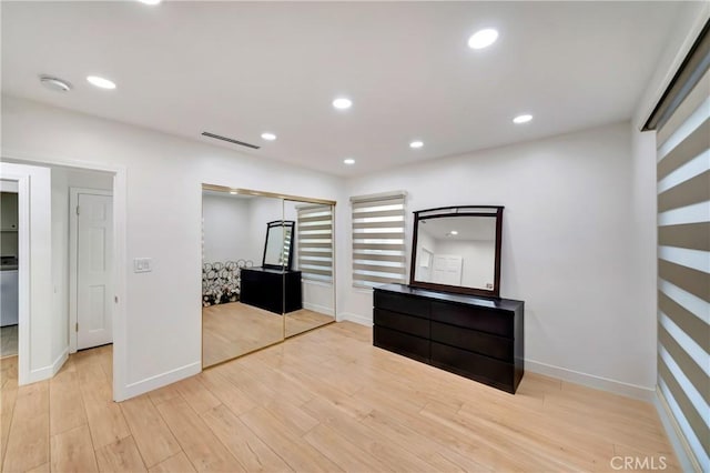 unfurnished bedroom featuring light hardwood / wood-style floors and a closet