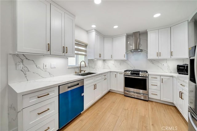 kitchen featuring white cabinets, wall chimney exhaust hood, sink, and stainless steel appliances