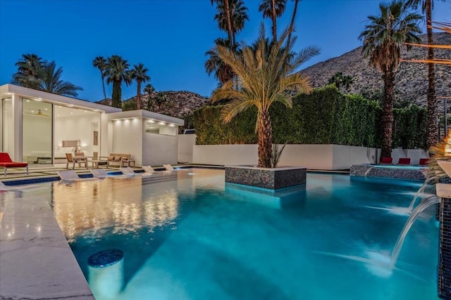 view of pool with pool water feature, a mountain view, and a patio area