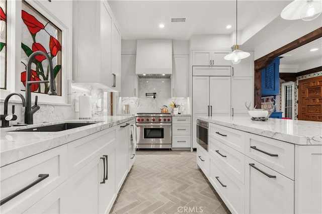 kitchen with white cabinets, custom range hood, and luxury range