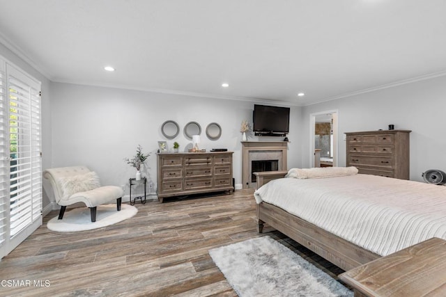 bedroom with ornamental molding and light hardwood / wood-style floors