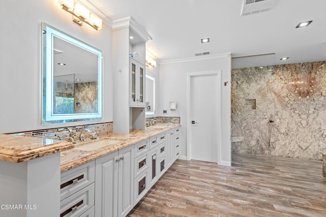 bathroom with wood-type flooring, vanity, decorative backsplash, a shower, and ornamental molding