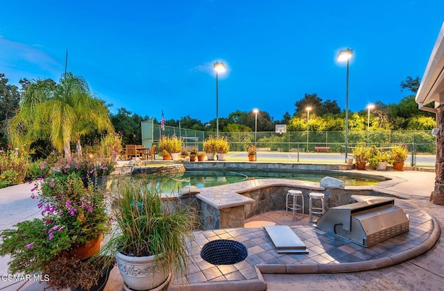 view of patio with exterior kitchen, a fenced in pool, and area for grilling