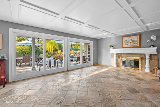 unfurnished living room with a high end fireplace, coffered ceiling, and beamed ceiling