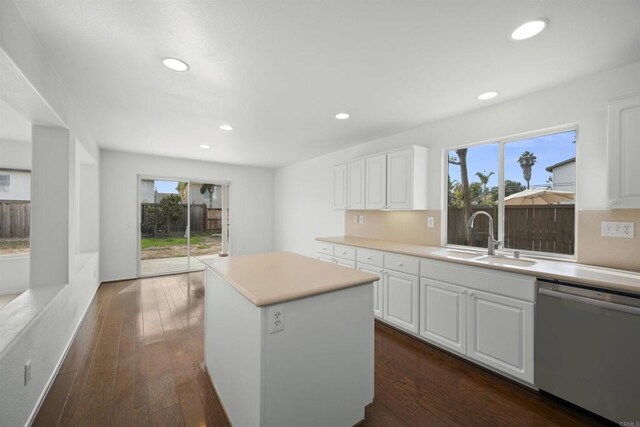 kitchen featuring dark hardwood / wood-style floors, a center island, stainless steel dishwasher, sink, and white cabinetry