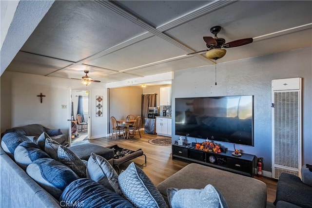 living room featuring ceiling fan, coffered ceiling, and hardwood / wood-style floors