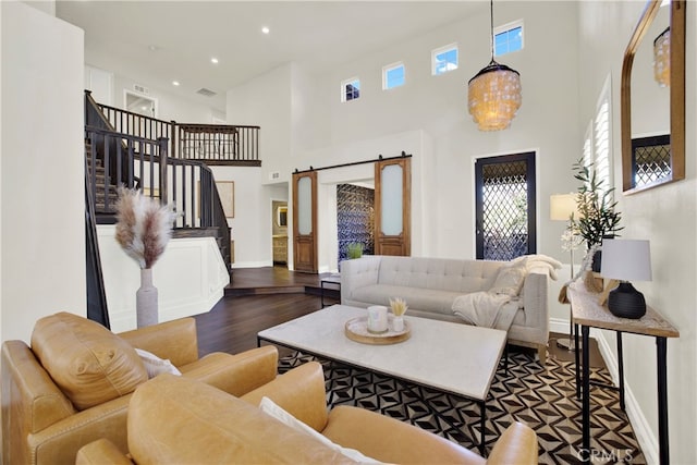 living room with a barn door, recessed lighting, baseboards, stairway, and dark wood-style floors