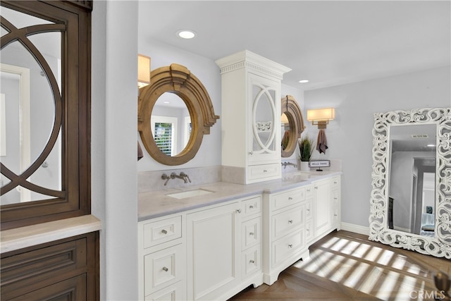 bathroom featuring parquet flooring and vanity