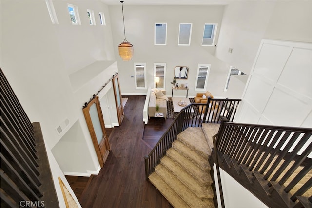 staircase featuring a high ceiling and wood-type flooring