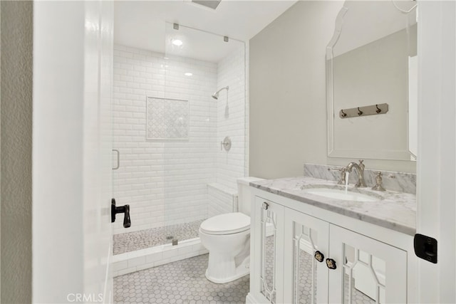 full bath featuring a stall shower, tile patterned flooring, vanity, and toilet