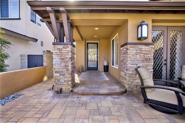 property entrance featuring stone siding and stucco siding