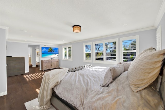 bedroom with baseboards, ornamental molding, and wood finished floors