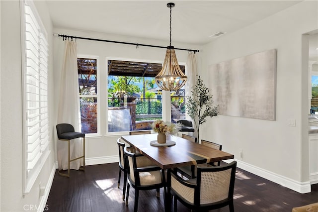 dining area featuring dark wood-style floors, visible vents, baseboards, and an inviting chandelier