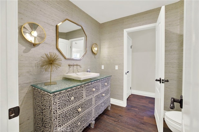 bathroom with hardwood / wood-style floors, toilet, and vanity