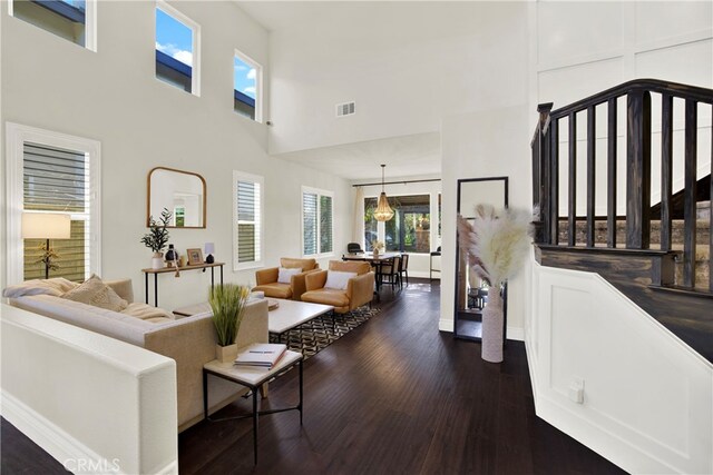 living room featuring a high ceiling and dark hardwood / wood-style flooring